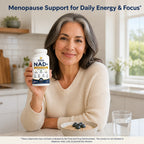 Woman in her 50s holding Soleu NAD+ for women 45+ in her kitchen at breakfast